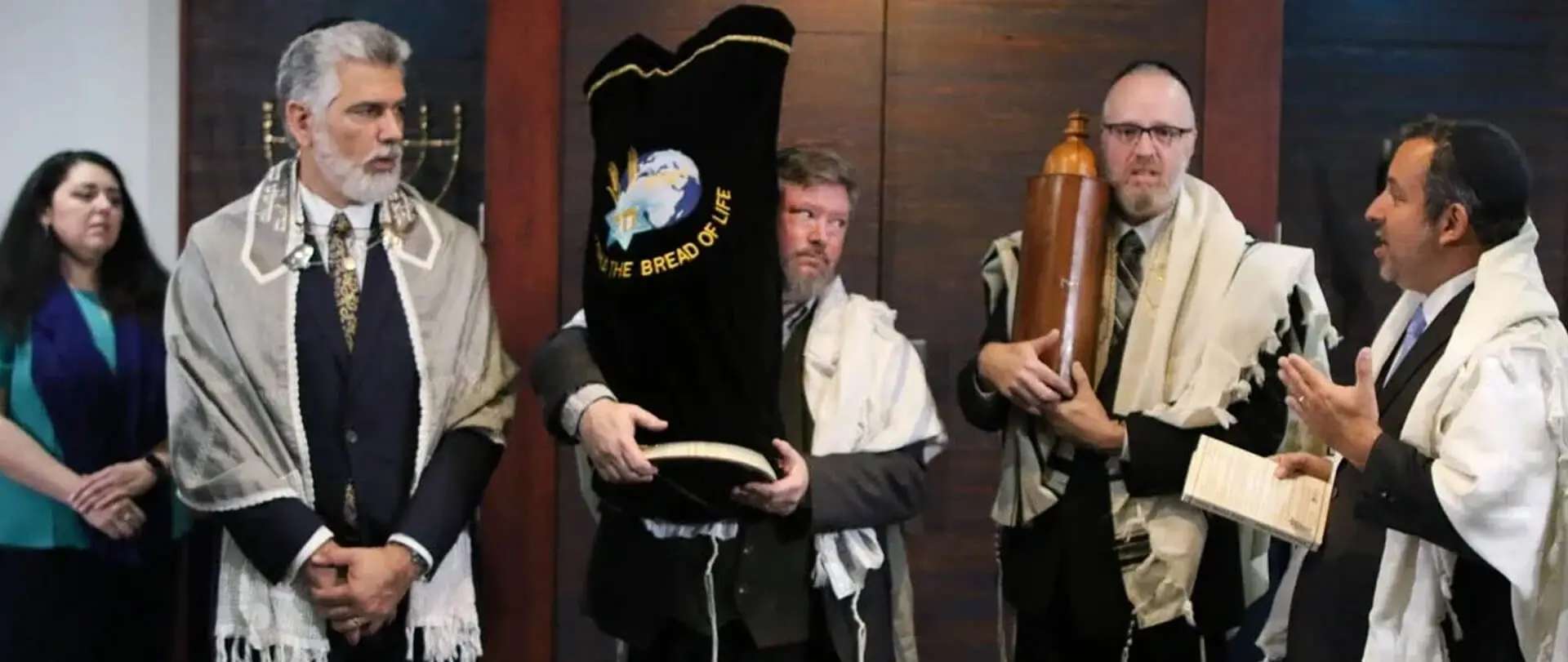 A group of people dressed in costumes and holding torah scrolls.