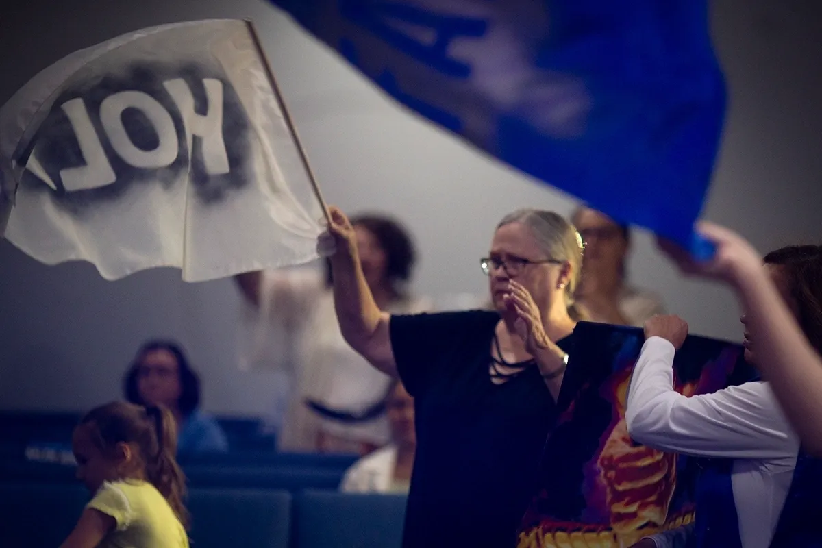 A woman holding up a sign that says " oh ".