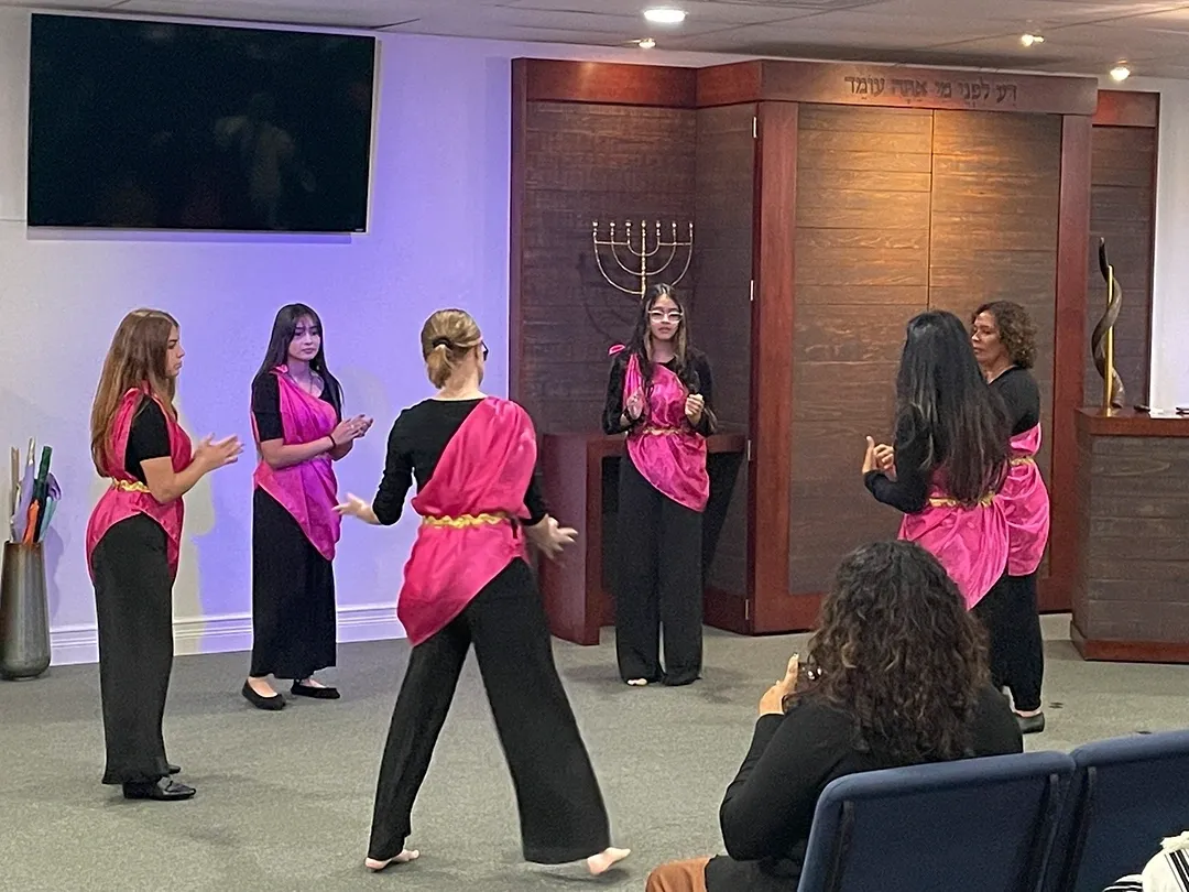 A group of women in pink and black outfits.
