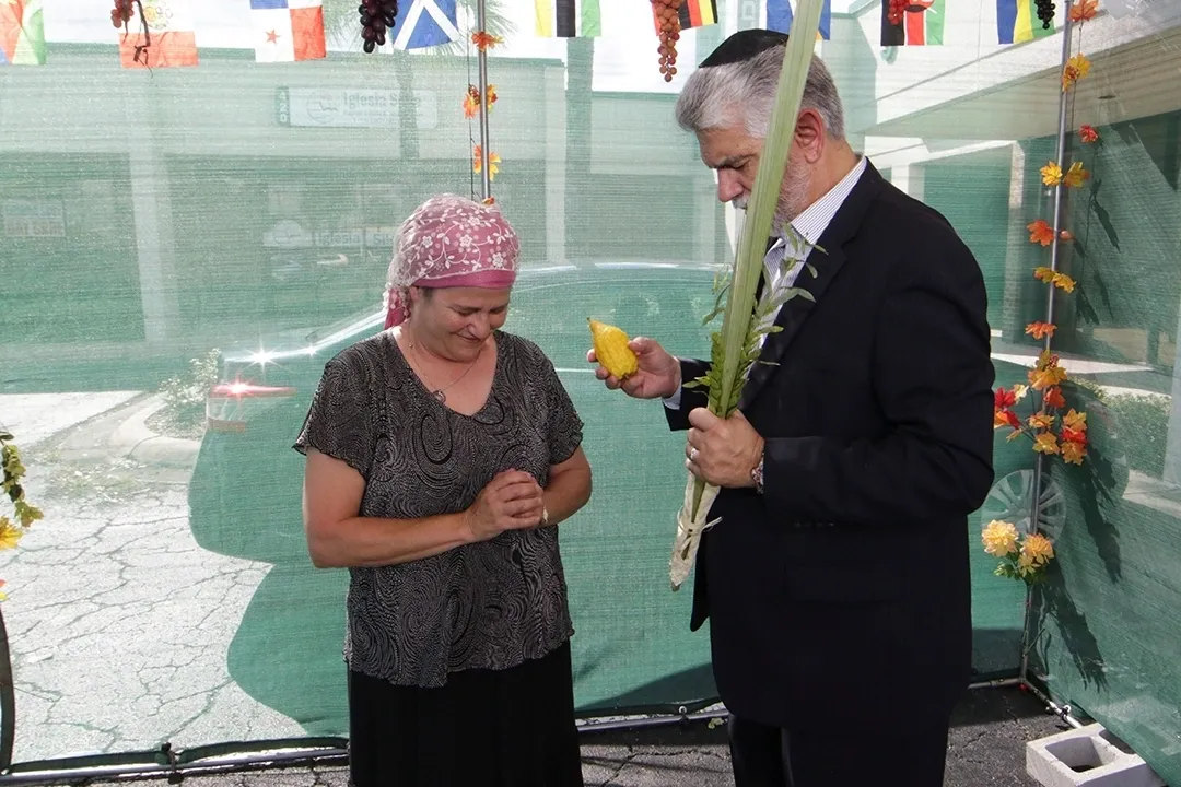A man and woman holding flowers in front of a pool.