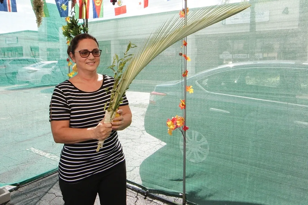 A woman holding a large piece of grass.