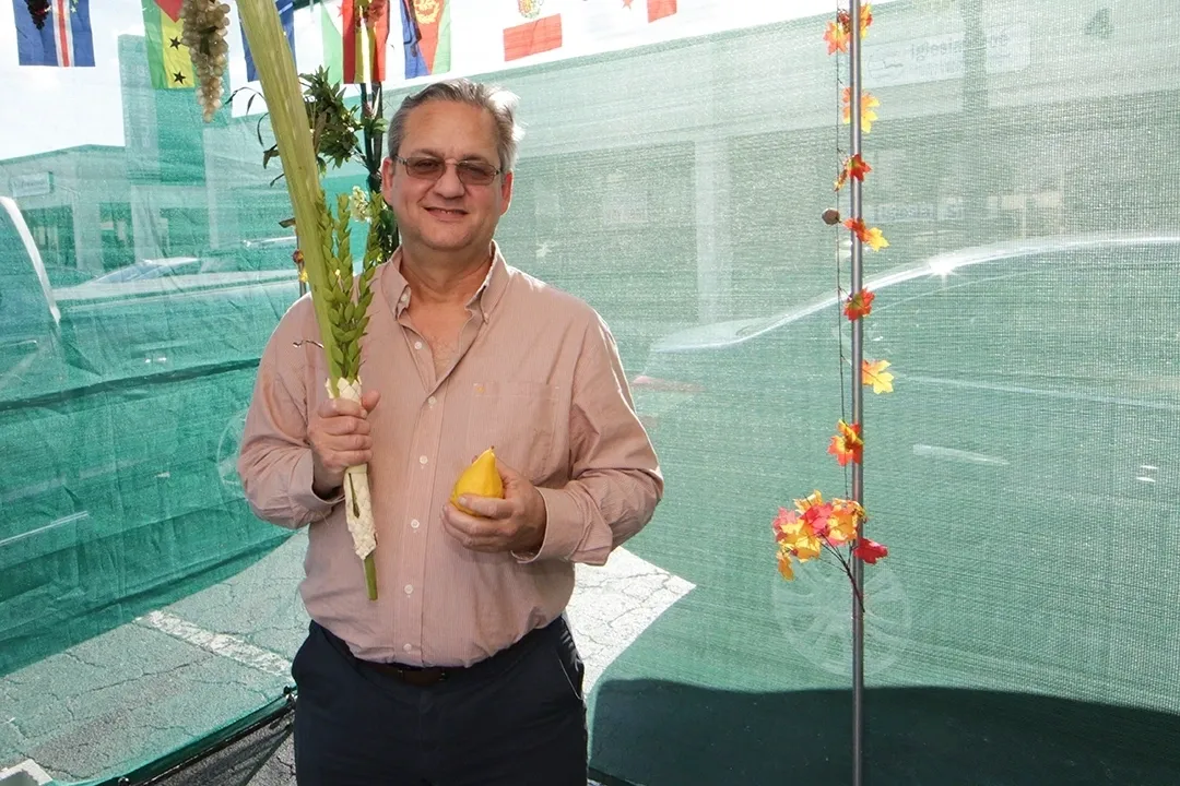 A man holding an orange and a plant