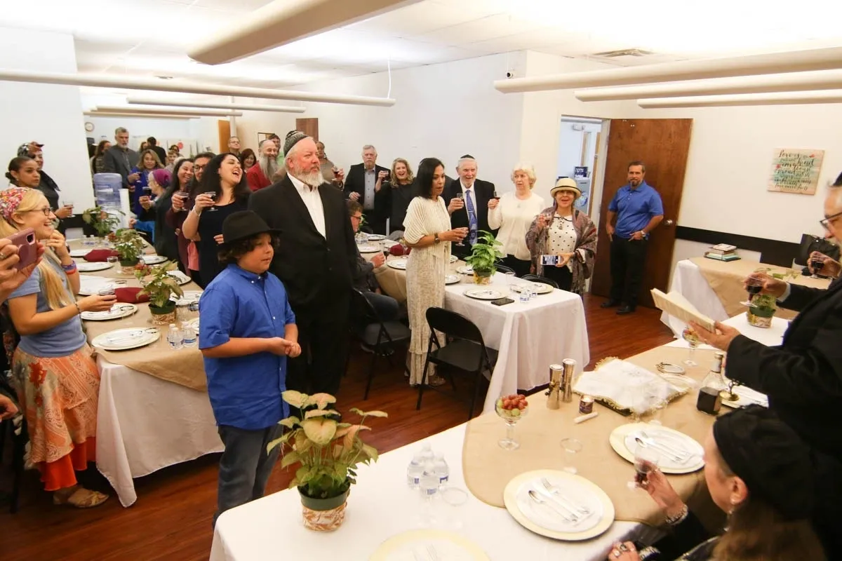 A group of people standing around tables with plates.