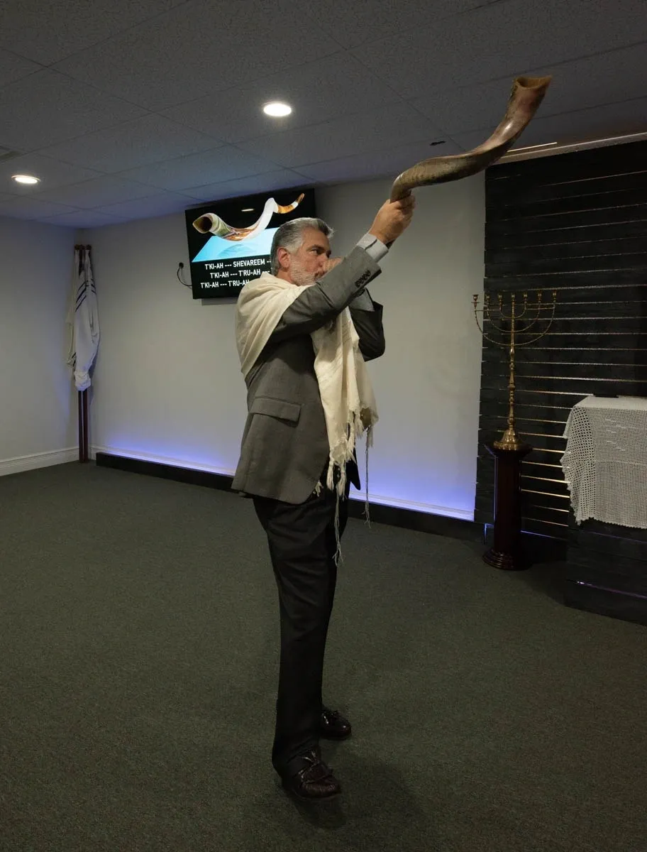 A man holding up a large snake in front of him.